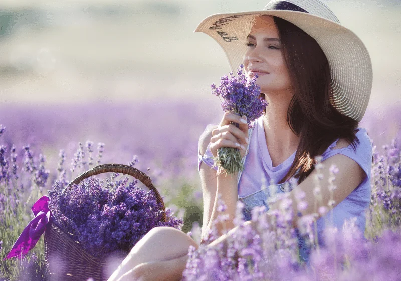 white woman smelling linalool in field of lavender