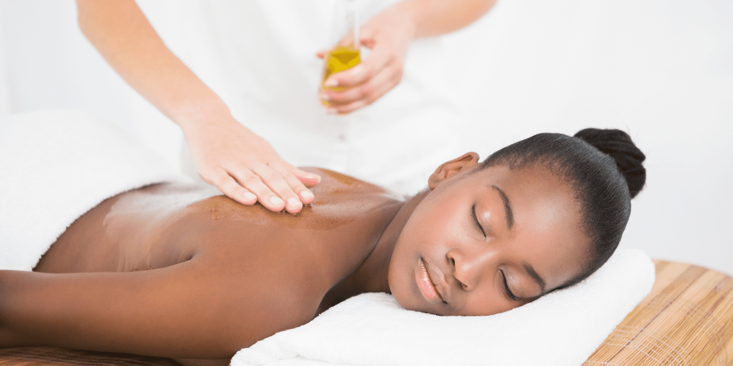 young black woman getting massage oil poured on her
